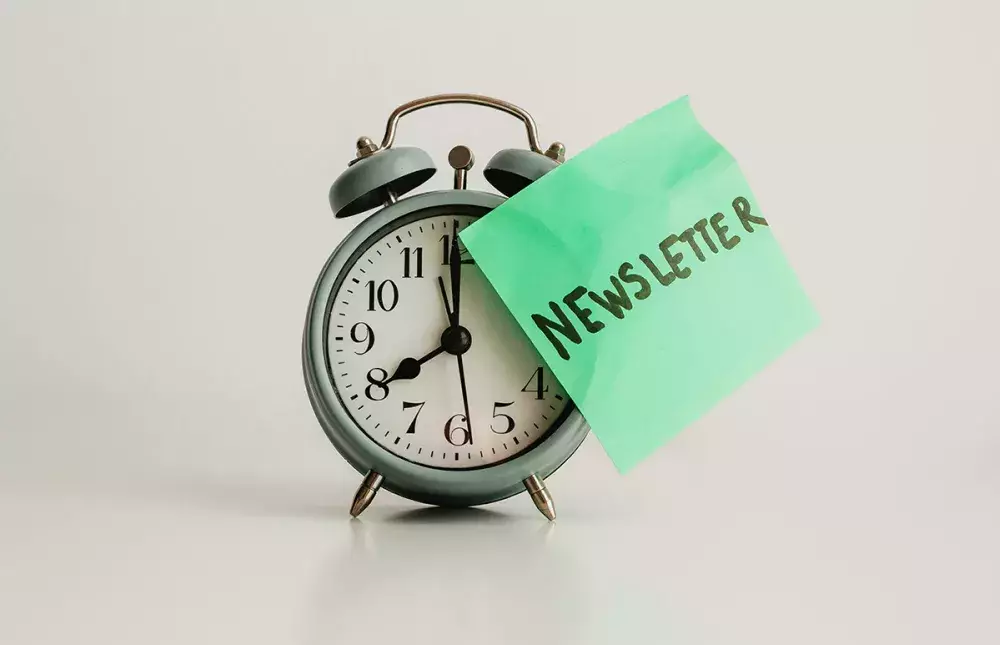Clock with a green newsletter sticky note