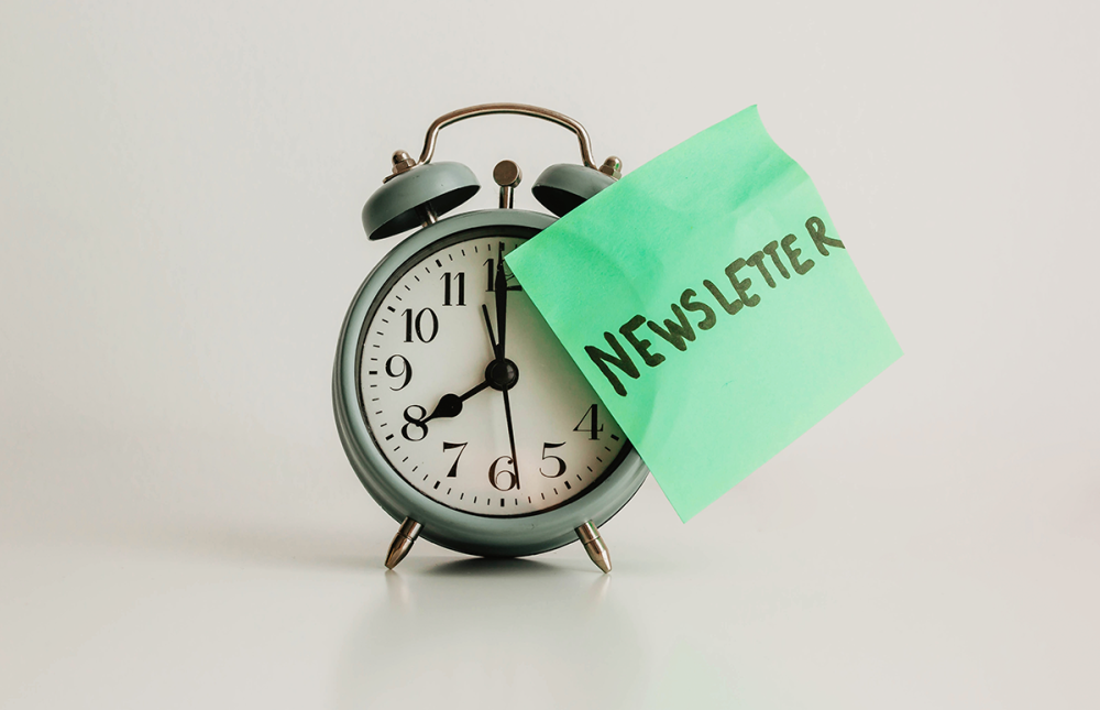 Clock with a green newsletter sticky note