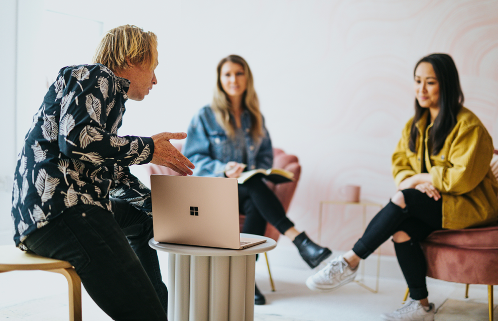 People siting around a laptop having a discussion