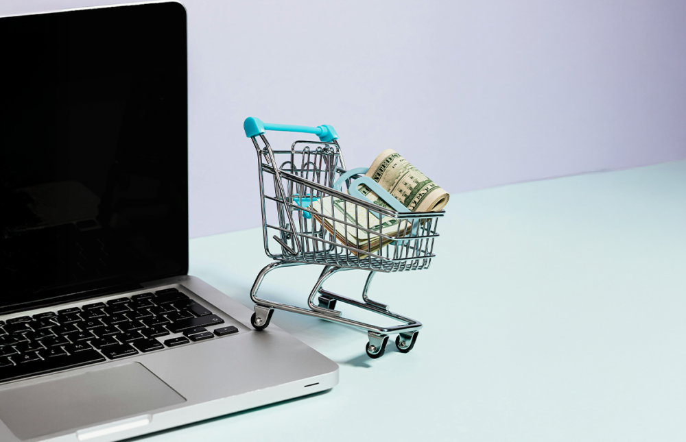 Mini Shopping cart next to a laptop 