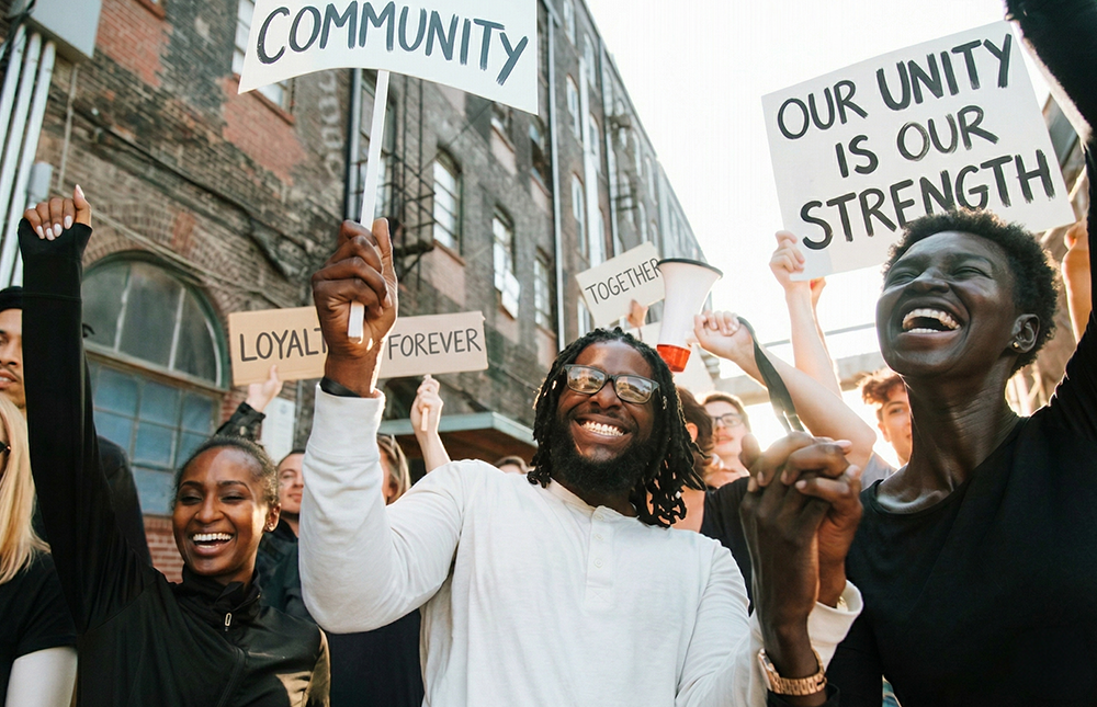 People outside with cards, protesting with a smile 