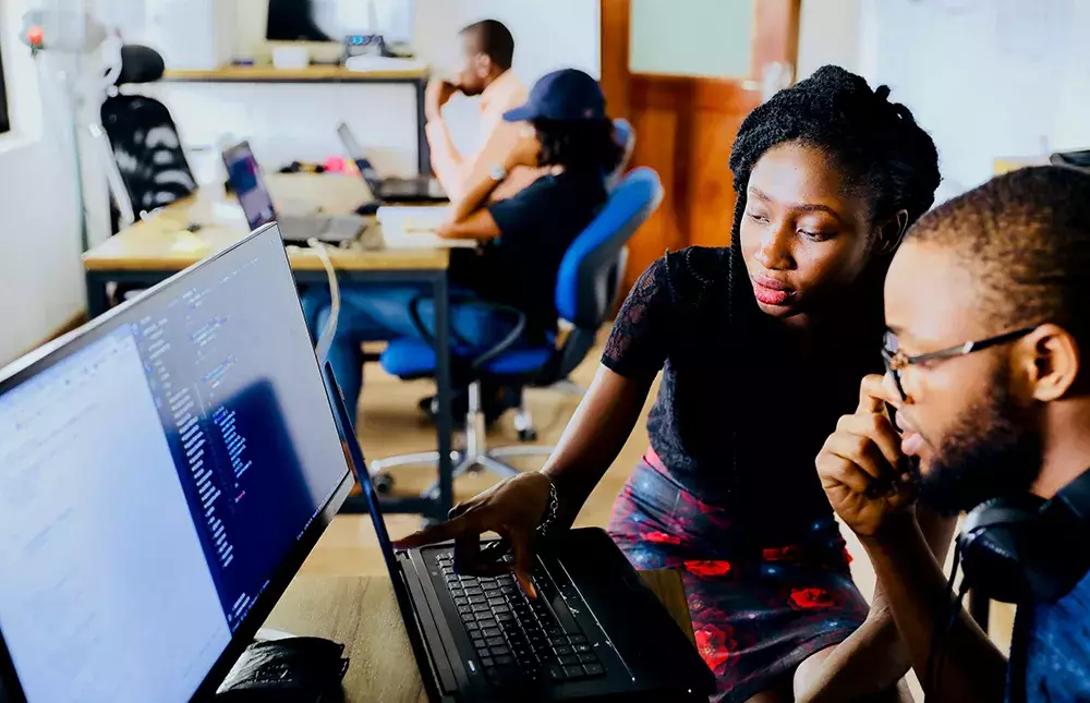 People sitting at computer screen and working